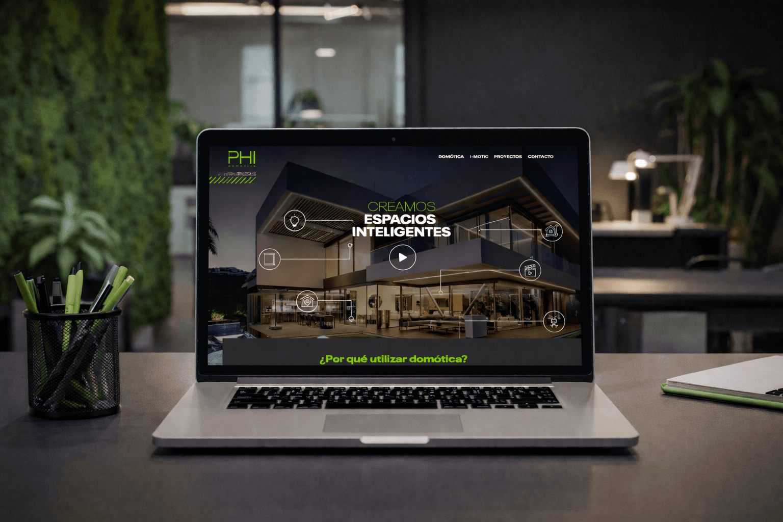 Sitio web de PHI Domótica abierto en una notebook, con el título Creamos espacios inteligentes